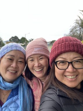 true friend | FAP News Today | Jaime smiles outside with two of her friends during a road trip. All three women are wearing beanies and warm jackets.