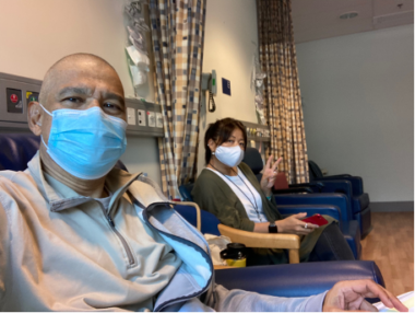 Aubrey in a mask sitting in a clinic receiving an infusion for his hATTR amyloidosis