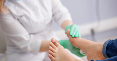 A doctor examining a person's feet