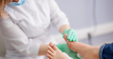 A doctor examining a person's feet